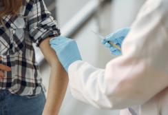 Ārsts ievada vakcīnu pacienta plecā